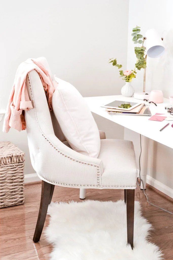 Bright home office with a pink throw over a white chair